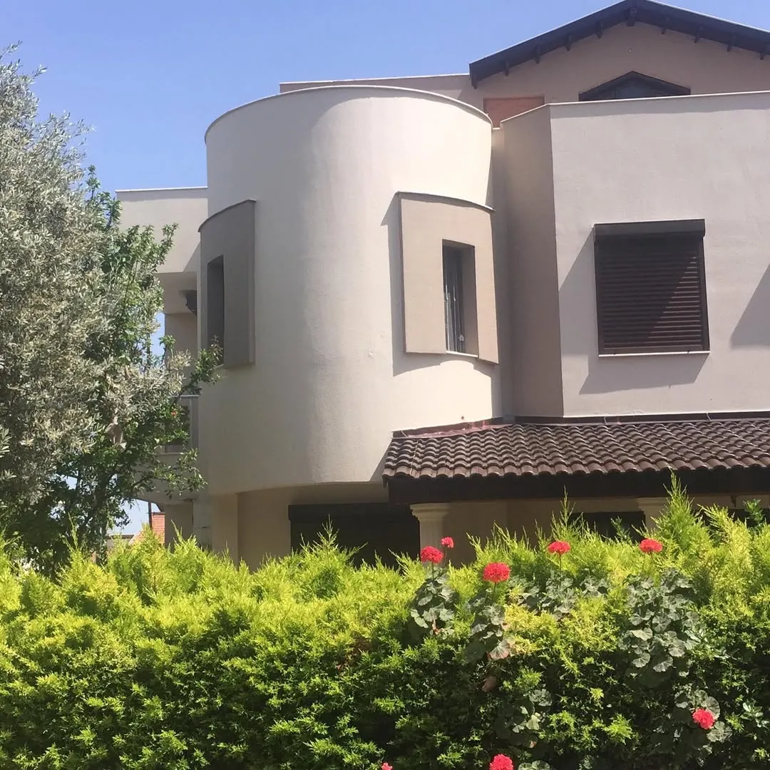 Yuvarlak kule detaylı krem renkli villa cephesi